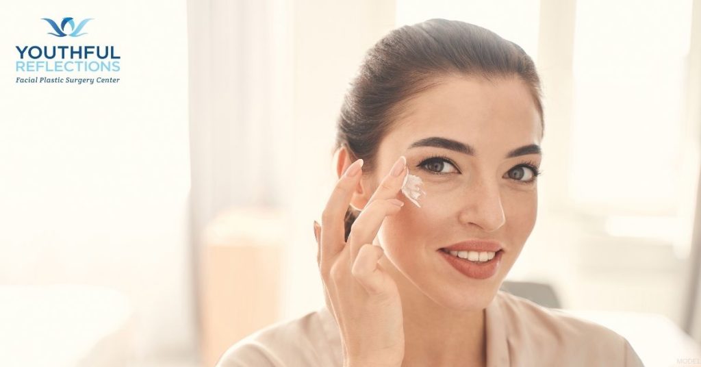 Woman applying cream to her under-eye (model)